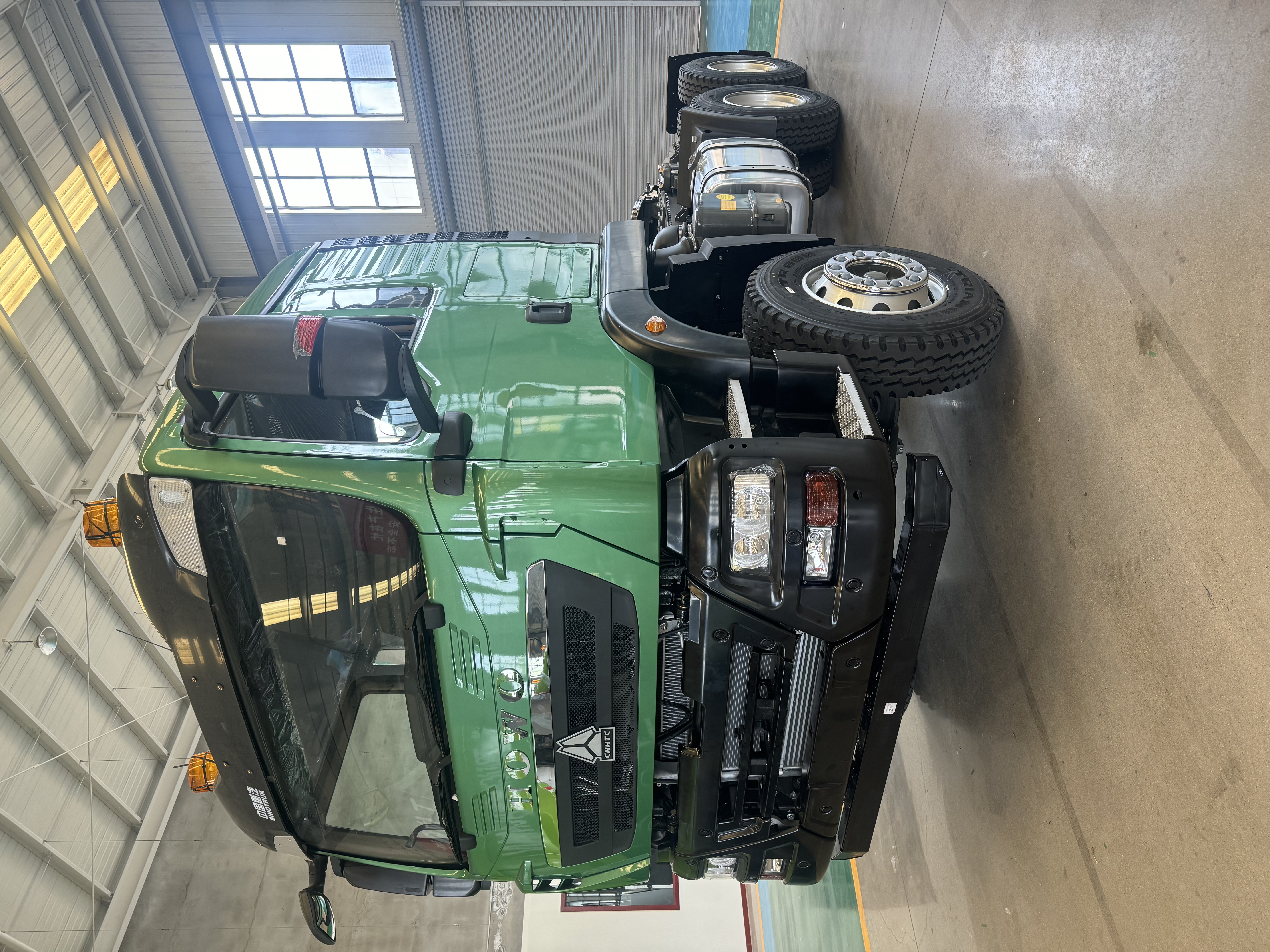 Green HOWO TX 6×4 tractor truck photographed indoors
